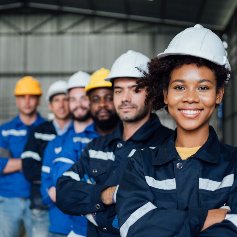 A maintenance team and production team stand together in a manufacturing factory